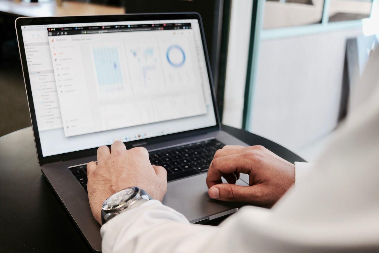 man on a laptop looking at sales graphs